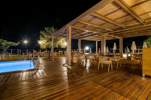 a pavilion with tables and a pool at night at AKASHA Beach Hotel & Spa in Hersonissos
