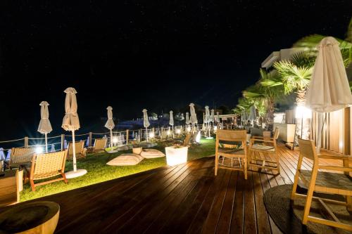 a deck with chairs and umbrellas at night at AKASHA Beach Hotel & Spa in Hersonissos
