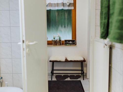 ein kleines Bad mit einem Fenster und einem Stuhl in der Unterkunft Finkenstüble in Sankt Peter