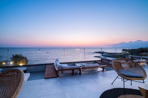 a balcony with a view of the ocean at sunset at AKASHA Beach Hotel & Spa in Hersonissos