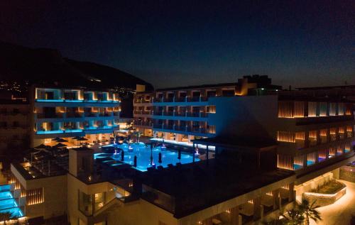 a building with a swimming pool at night at AKASHA Beach Hotel & Spa in Hersonissos