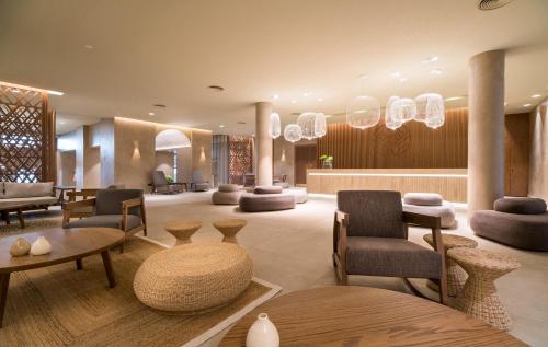a hotel lobby with chairs and tables and chandeliers at AKASHA Beach Hotel & Spa in Hersonissos