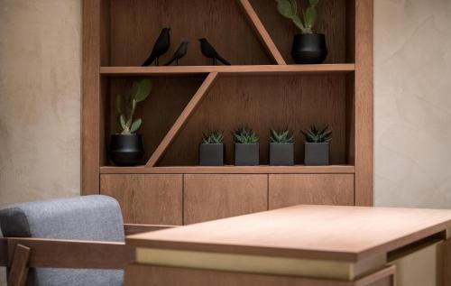 a wooden shelf with potted plants on it at AKASHA Beach Hotel & Spa in Hersonissos