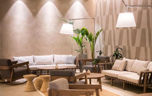 a living room with couches and tables and plants at AKASHA Beach Hotel & Spa in Hersonissos