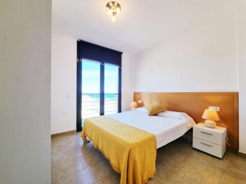 a bedroom with a bed and a large window at Apartamento Medusa in L'Escala