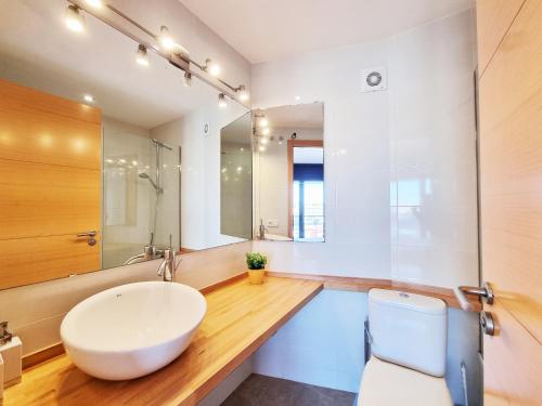 a bathroom with a white sink and a toilet at Apartamento Medusa in L'Escala