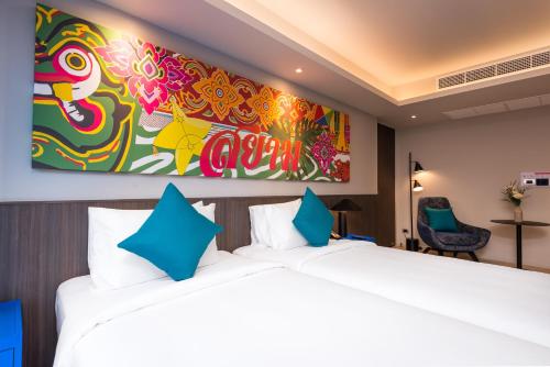 a bedroom with a large bed and a painting on the wall at Maitria Hotel Rama 9 Bangkok - A Chatrium Collection in Bangkok