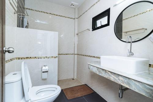 a bathroom with a toilet and a sink and a mirror at Thai Smile Resort in Rayong