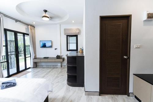 a room with a bed and a sink and a door at Thai Smile Resort in Rayong
