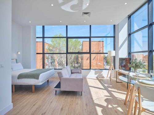 a bedroom with a bed and a couch and a table at Paseo Suites Hotel in Madrid