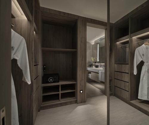 a bathroom with a walk in closet with a sink at Pan Pacific Serviced Suites Kuala Lumpur in Kuala Lumpur