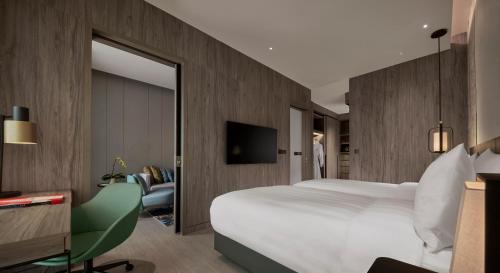 Habitación de hotel con cama grande y espejo en Pan Pacific Serviced Suites Kuala Lumpur en Kuala Lumpur