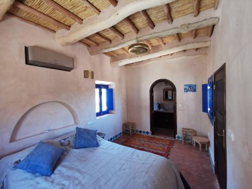 1 dormitorio con 1 cama grande con almohadas azules en Bab El Atlas, en Kalaat MGouna