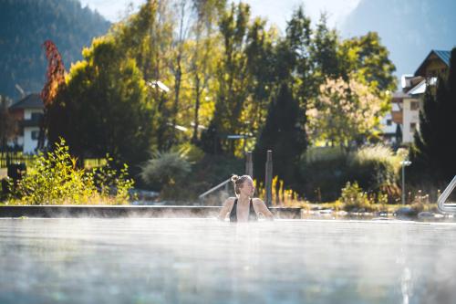 a woman in the water in a swimming pool at Rieser Achensee Resort in Pertisau