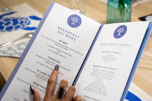 iemand die een menukaart omhoog houdt bij Sati Villa Rekawa Beach Sri Lanka in Tangalle