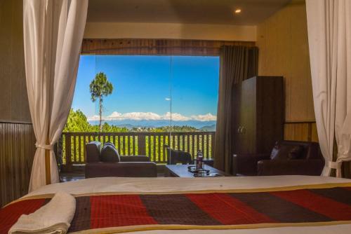 阿爾莫拉的住宿－The Himalayan Heights Satya's kasardevi，一间卧室设有一张床和一个美景阳台