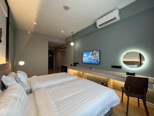 a bedroom with a bed and a tv on the wall at FUHOTEL in Bukit Mertajam