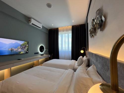 a hotel room with two beds and a flat screen tv at FUHOTEL in Bukit Mertajam