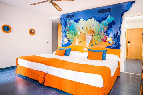 a bedroom with a large bed with a disney mural on the wall at Diverhotel Roquetas in Roquetas de Mar