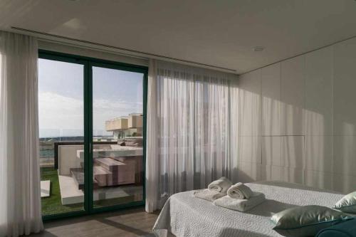 ヴィラモウラにあるMarina Vilamoura Penthouse Aquamar 606のベッドルーム1室(ベッド2台、大きな窓付)