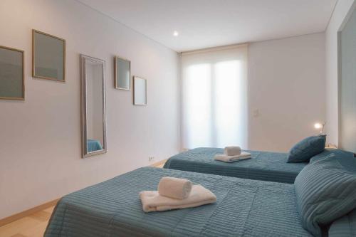 two beds with towels on them in a bedroom at Aquamar 416 by Vilamoura Sun espaçoso in Vilamoura