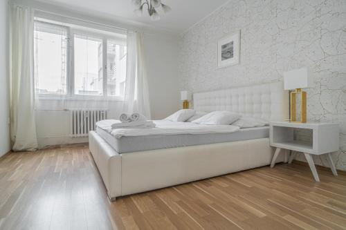 プラハにあるLovely apartment Miriamの白いベッドルーム(大型ベッド1台、窓付)