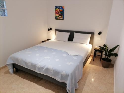 a bedroom with a white bed and a plant at Carpe Diem Ierissos in Ierissos
