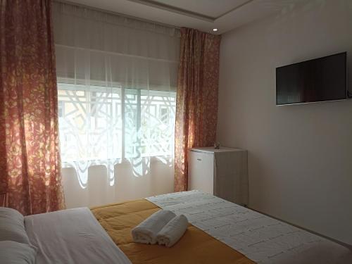 una camera da letto con un letto, una TV e una finestra di Cozy duplex a Rabat