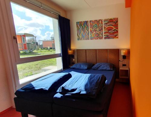 a bedroom with a bed and a large window at Camping Zeeburg Amsterdam in Amsterdam