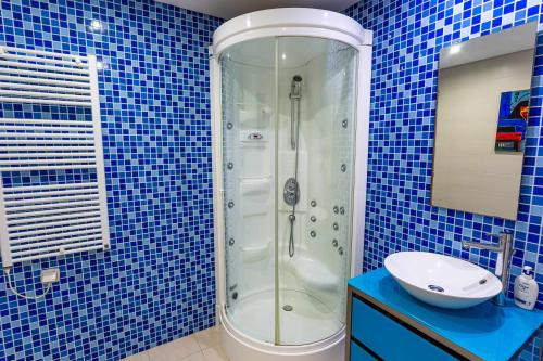 ヴィラモウラにあるVilamouraSun Aquamar 410 Vista marinaの青いタイル張りのバスルーム(シャワー、シンク付)