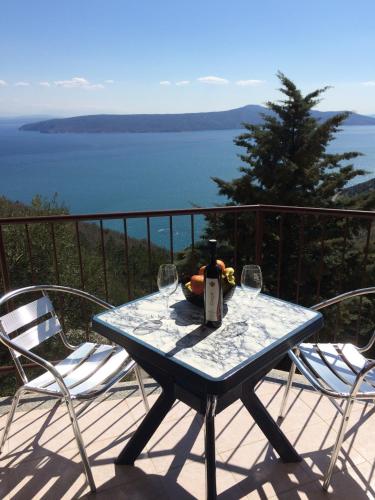 a table with two chairs and a bottle of wine at Apartment Bertossin Rovini in Mošćenička Draga