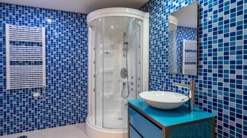 y baño de azulejos azules con lavabo y ducha. en VilamouraSun Aquamar 110 Pool and Marina View, en Vilamoura