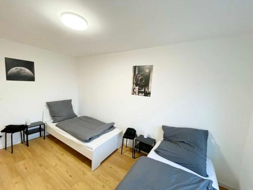 een slaapkamer met 2 bedden en 2 krukken bij Apartments in Rosbach vor der Höhe in Rosbach vor der Höhe