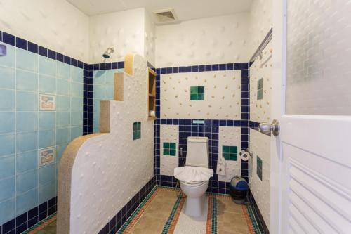 a bathroom with a toilet and blue and white tiles at Phranang Place- SHA Extra in Ao Nang Beach