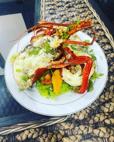 een bord met eten, met kreeft op een salade bij Nasara Resort Mentawai in Tua Pejat