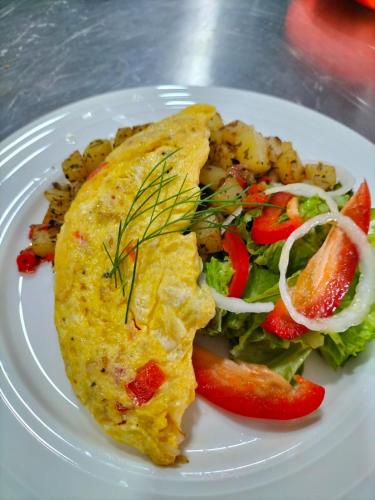 een bord eten met een omelet en een salade bij Nasara Resort Mentawai in Tua Pejat