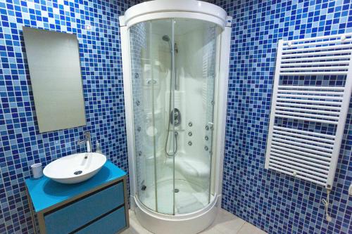 a blue tiled bathroom with a shower and a sink at Marina Vilamoura Aquamar 320 by Vilamoura Sun in Vilamoura