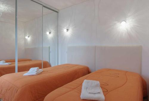 ヴィラモウラにあるBoat View Marina Plaza By VilamouraSunのベッド2台と鏡が備わる客室です。