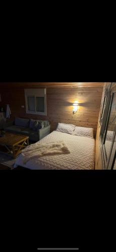 a bedroom with a bed in a wooden wall at צימר סאפי in Nimrod