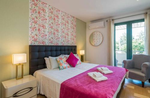 ヴィラモウラにあるMarina Vilamoura Aquamar 104 By Vilamoura Sunのベッドルーム1室(ピンクの毛布付きの大型ベッド1台付)