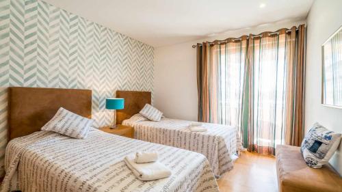 a hotel room with two beds and a couch at Marina Vilamoura Aquamar 120 By Vilamoura Sun in Vilamoura