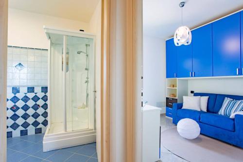 uma casa de banho com armários azuis e um sofá azul em Casa a Telti by Wonderful Italy em Telti
