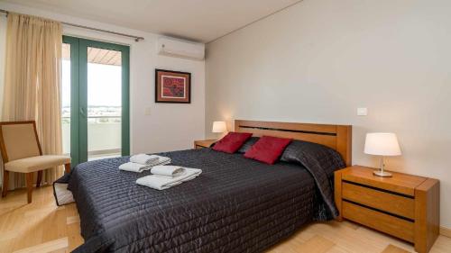 a bedroom with a large bed with towels on it at Marina Vilamoura Aquamar 203 By Vilamoura Sun in Quarteira
