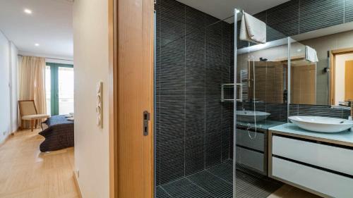 a bathroom with a sink and a glass shower at Marina Vilamoura Aquamar 203 By Vilamoura Sun in Quarteira