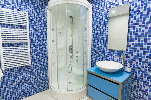 a blue tiled bathroom with a shower and a sink at Marina Vilamoura - Aquamar 217 - By Vilamoura Sun in Quarteira