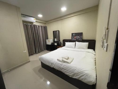 een slaapkamer met een bed met twee handdoeken erop bij Hug me guesthouse in Pattaya