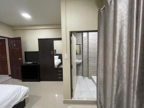 1 dormitorio con cortina de ducha y baño en Hug me guesthouse, en Pattaya central