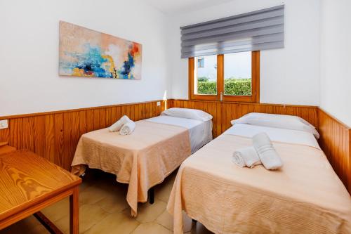 a room with two beds and a window at Les Ancores in Alcudia