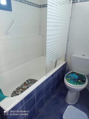 a bathroom with a toilet and a bath tub with a shower at Villa Chara in Paphos