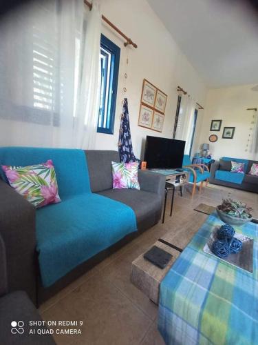 a living room with a blue couch and a table at Villa Chara in Paphos